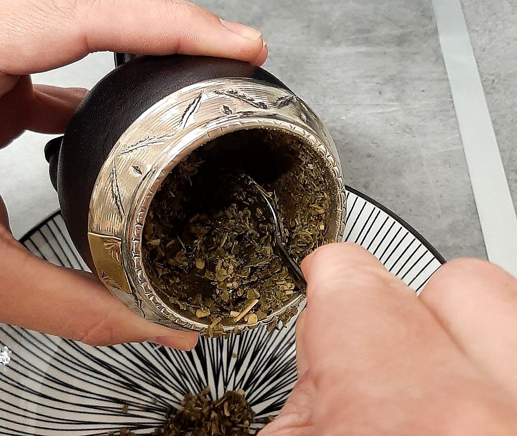 Retiro de yerba usada de un mate de calabaza
